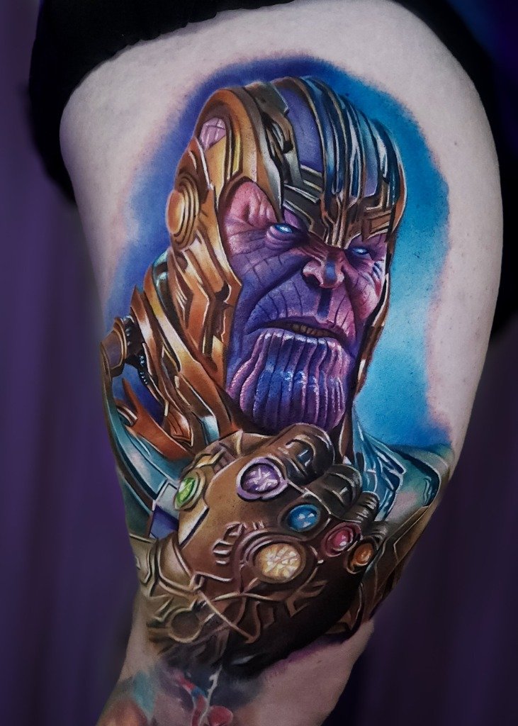 Tatuaje realista a color de Thanos de Marvel en el muslo