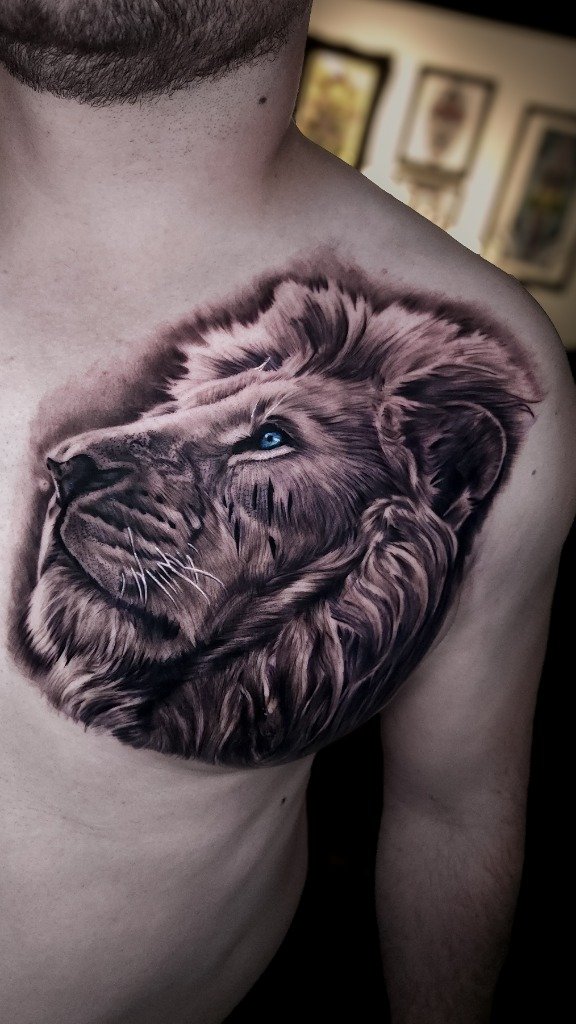 Tatuaje Realista en Sombras de León en el Pecho con Ojos Celestes